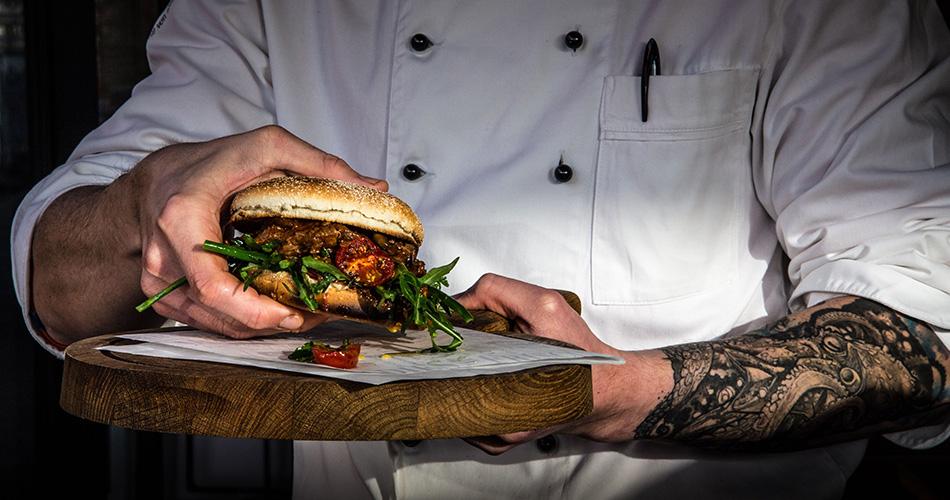 Kategorie Burger Fertig angerichteter Burger in der Hand des Kochs